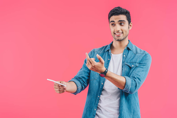 portrait of man with smartphone showing middle finger isolated on pink - Fotoğraf, Görsel