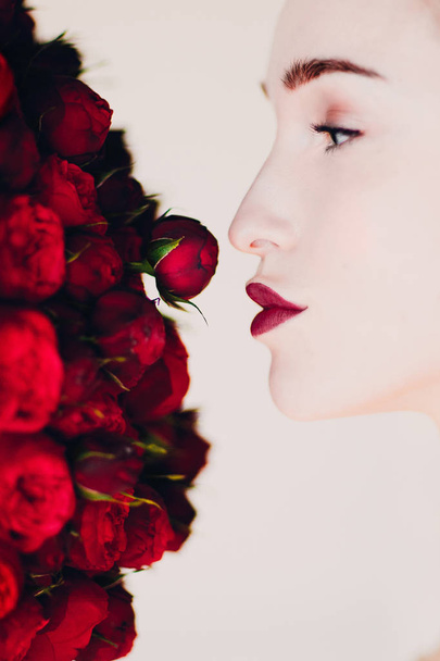 Красива жінка модель і букет червоних квітів
. - Фото, зображення