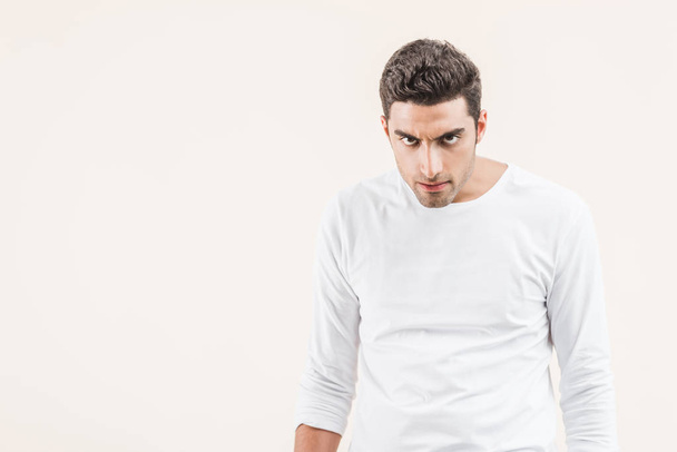 aggressive young man looking at camera isolated on beige - Photo, Image