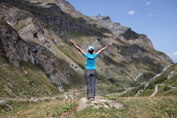 mujer con los brazos abiertos en un paisaje montañoso
 - Foto, Imagen