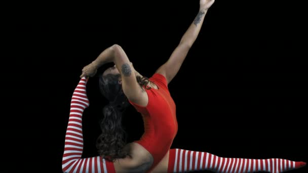 Νεαρή γυναίκα να κάνει Γιόγκα ασκήσεις σε μαύρο φόντο - Πλάνα, βίντεο