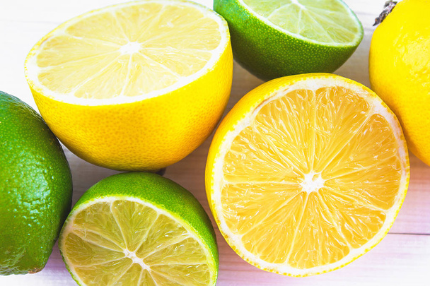 lemons and limes on a wooden background. - Foto, Imagem