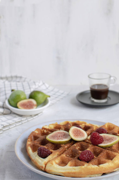 Valikoiva painopiste Belgian vohvelit Hidas ruoka aamiainen konsepti viikunat vadelmat hunaja Espresso kahvi Checkere lautasliina valkoinen puinen tausta Vaaka Persoonallinen
 - Valokuva, kuva