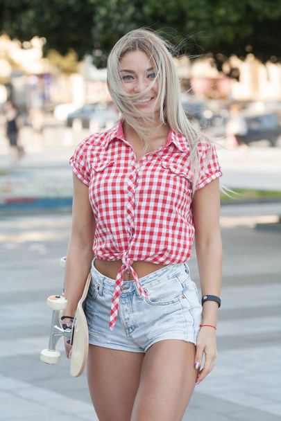 Beautiful and fashion young blonde woman posing with a skateboard - Foto, Bild