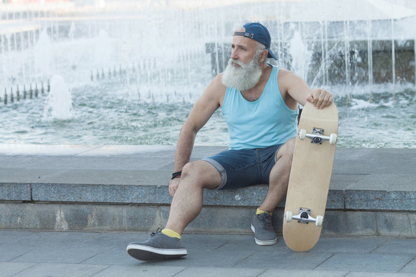 Vieil homme énergique qui aime faire du skateboard
 - Photo, image