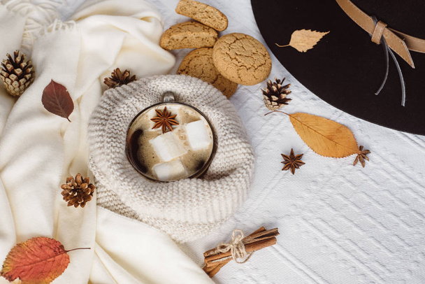 Autumn and Winter composition. Hot coffee with marshmallows, scarf, cookies, hat, bumps and autumn leaves. Flat lay, top view - Valokuva, kuva