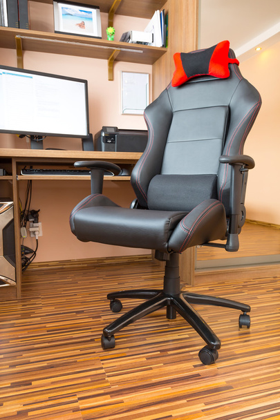 Офісне крісло за комп'ютерним столом вдома
 - Фото, зображення