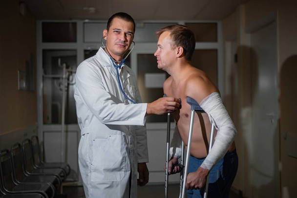 Homme médecin écoute le client à l'aide d'un stéthoscope à l'hôpital
 - Photo, image