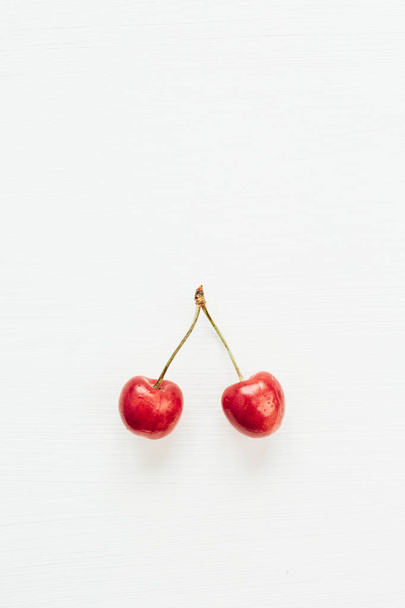 De vertakking van de Cherry bessen geïsoleerd op een witte achtergrond. Plat lag, top uitzicht minimale concept. - Foto, afbeelding