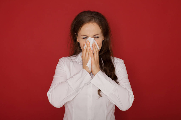 the girl with the runny nose, isolated on red background - Photo, image