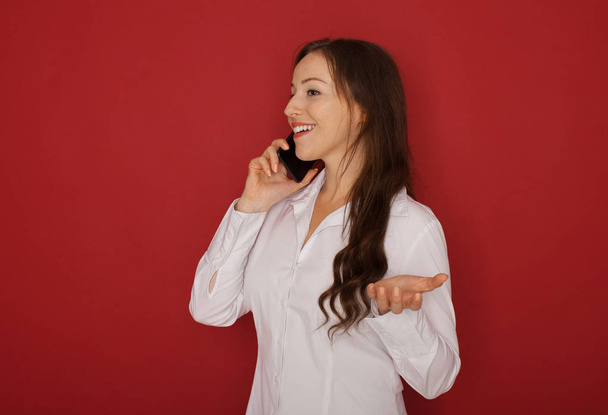 Portrait of smiling business woman phone talking, isolated on red background - Foto, immagini