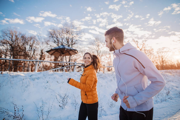 Happy usmívající se sportovní mladý pár běhání v zimě sportovní, venkovní trénink - Fotografie, Obrázek