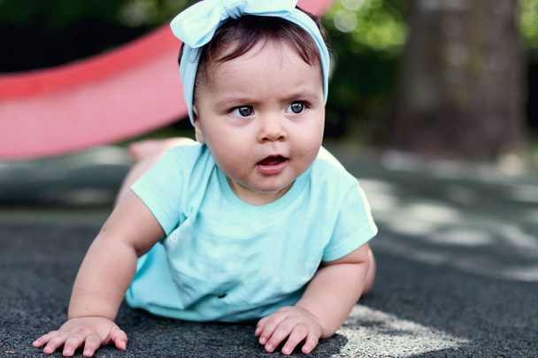 kültéri portré egy gyönyörű baba négykézláb. térd gyermek a földön csúszó - Fotó, kép