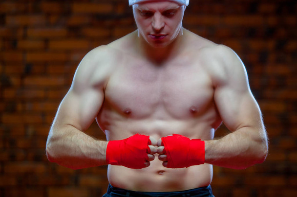 No Natal. Lutador muscular kickbox boxe Papai Noel com ligaduras vermelhas o fundo de uma parede de tijolo
. - Foto, Imagem
