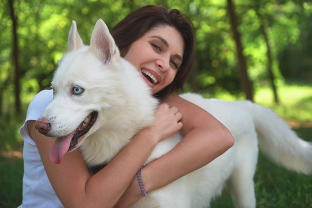 彼女のハスキー犬、親友を抱いて幸せな笑みを浮かべて少女をクローズ アップ - 写真・画像