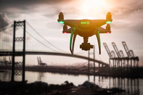 Silhueta do sistema de aeronaves não tripuladas (UAV) Quadcopter Drone no ar sobre o porto de transporte
. - Foto, Imagem