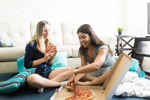 Többnemzetiségű női meg élvezi pizza után pizsama party otthon - Fotó, kép