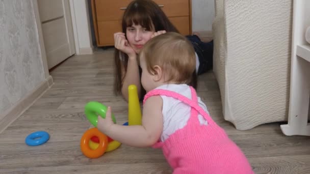 malá dcerka sbírá barevné designer, Máma hraje s dítětem v dětském pokoji - Záběry, video
