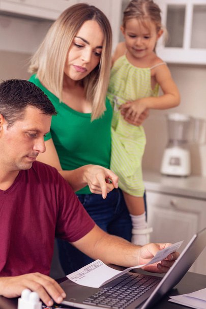 Man doing his bills - Worried young couple calculating finances at home - Photo, Image