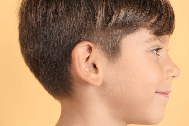 Cute little boy on color background, closeup. Hearing problem - Zdjęcie, obraz