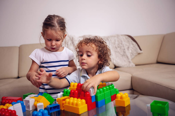 tiempo en familia Linda chica y niño jugando con juguetes y divertirse juntos
 - Foto, Imagen