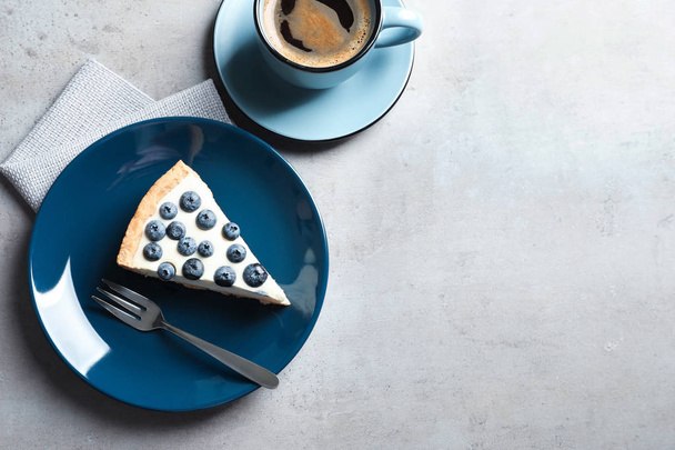 Flat lay composition with piece of tasty blueberry cake and space for text on gray table - Фото, зображення