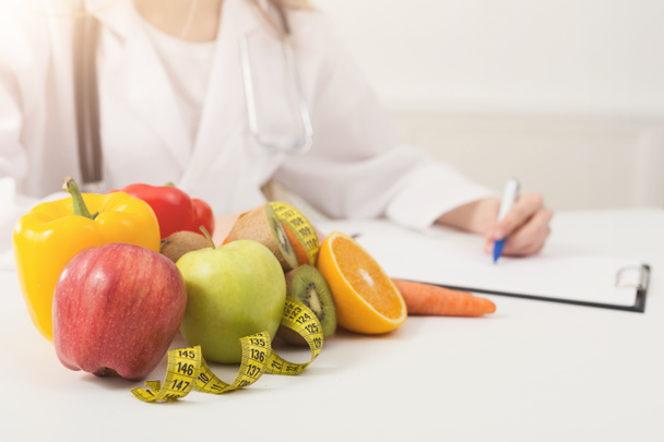 Ravitsemusterapeutin pöytä hedelmillä ja mittanauhalla
 - Valokuva, kuva