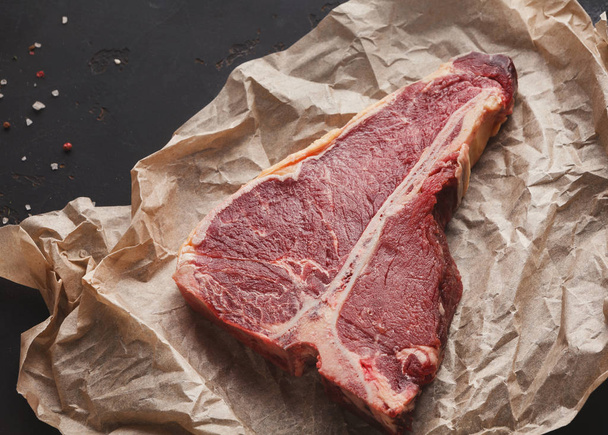 Raw t-bone steak on craft papper closeup - Fotoğraf, Görsel