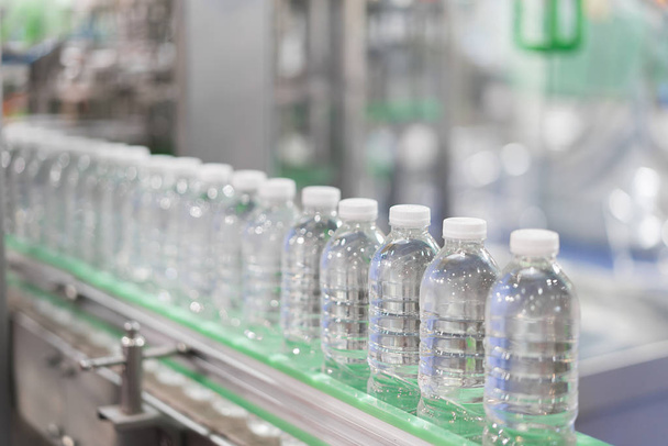 明確な水のボトルは、コンベア ベルト システムに転送します。産業と機械技術コンセプトと工場. - 写真・画像