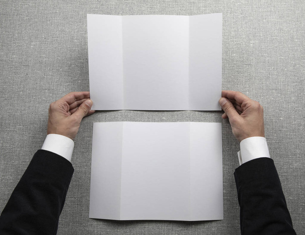 Manos de hombre sosteniendo folleto blanco vacío
 - Foto, imagen
