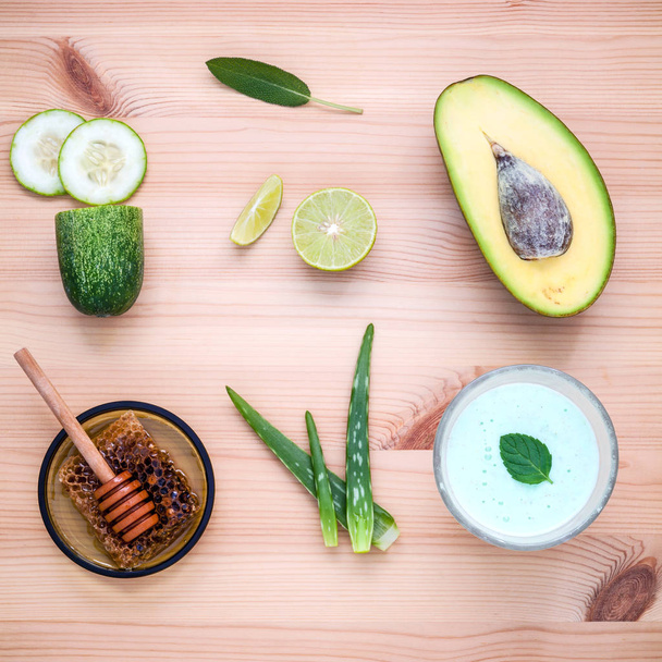 Homemade skin care and body scrub with natural ingredients avocado ,aloe vera ,lemon,cucumber and honey set up on wooden background. - Фото, зображення