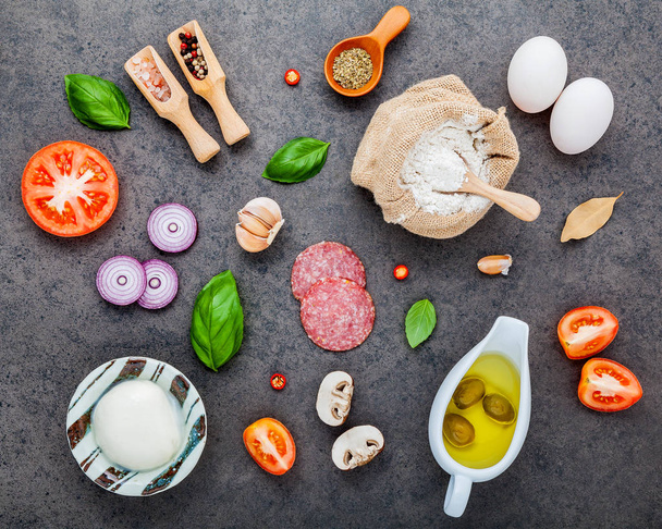 The ingredients for homemade pizza on dark stone background. - Photo, Image