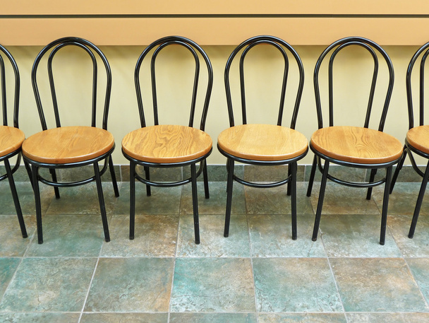 Empty chairs lined up against a wall - Zdjęcie, obraz