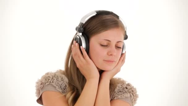Κορίτσι να ακούτε μουσική στα ακουστικά και να καλύπτει το πρόσωπό της με τα χέρια - Πλάνα, βίντεο