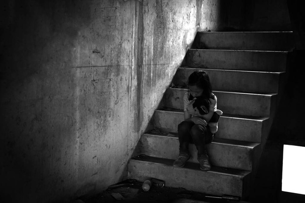 Przygnębiona młoda dziewczyna siedzi sama w opuszczonym budynku, zaniedbanych, dzieci z zaburzenia emocjonalne i behawioralne - Zdjęcie, obraz
