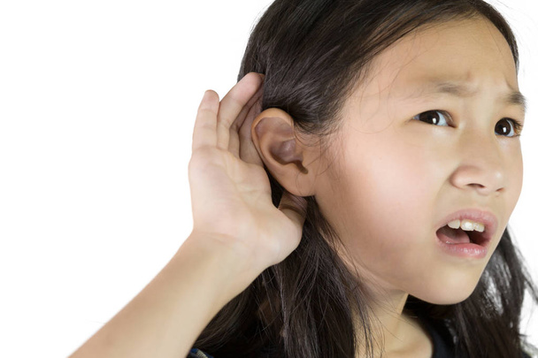 Ασιατικό κορίτσι που ακούει από τα χέρια μέχρι το αυτί απομονωθεί σε λευκό φόντο, τα παιδιά με προβλήματα ακοής. - Φωτογραφία, εικόνα