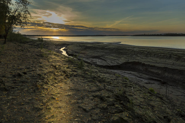 Příkrého břehu řeky pozadí zapadajícího slunce - Fotografie, Obrázek