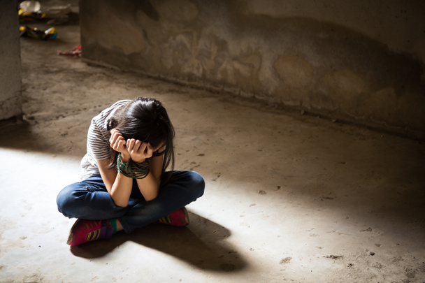 Ázsiai lány a kezével kötve egy elhagyatott épületben, erőszak, emberkereskedelem fogalmát visszaél stop - Fotó, kép