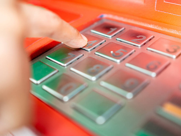 Zbliżenie palca Wstawianie hasło na bankomat. Ręcznie, wprowadzając numer kodu lub kod pin na przycisk na klawiaturze komputera banku. - Zdjęcie, obraz