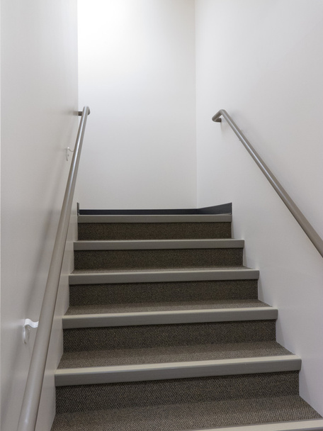 Дивлячись добре освітлені сходи з поручнями
 - Фото, зображення