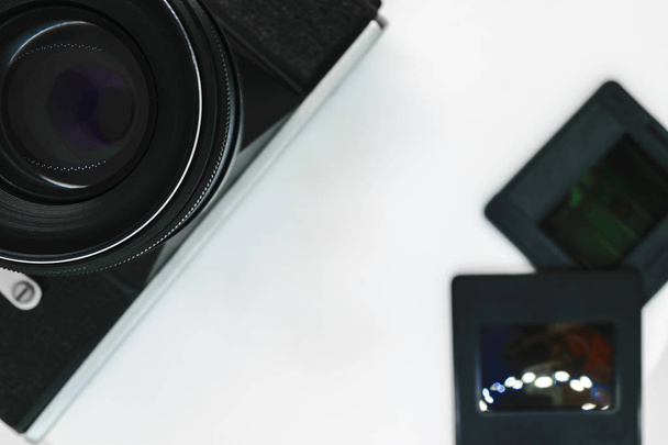 Très vieil appareil photo vintage noir avec lentille noire vue du haut avec espace de copie et fond blanc avec deux diapositives photo
 - Photo, image