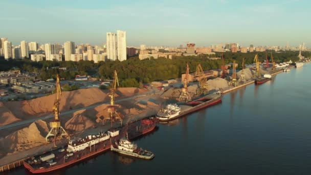 Panoramablick auf den Flusshafen mit im Wasser verankerten Flottenkähnen am Ufer. Landschaft mit großem welligem Fluss - Filmmaterial, Video