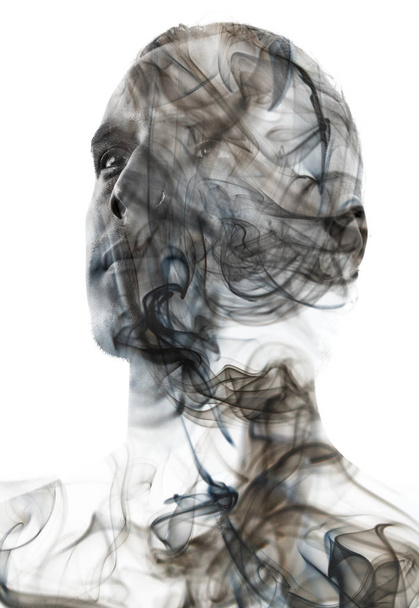 Unique conceptual work bringing together the unpredictable nature of swirling smoke with the firm gaze of a young attractive man - Foto, Imagen