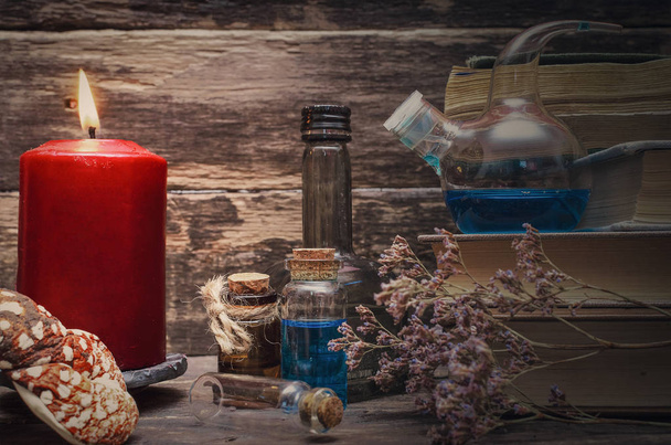 Essential oil bottles and old books. Herbal medicine. Magic potion in the vial on the wizard table. Witchcraft concept. - Φωτογραφία, εικόνα