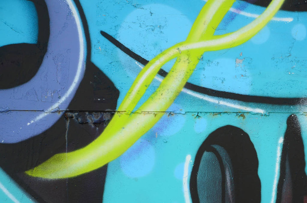 Fragment van graffiti tekeningen. De oude muur versierd met verf vlekken in de stijl van straatkunst cultuur. Gekleurde achtergrond textuur in koude tinten. - Foto, afbeelding