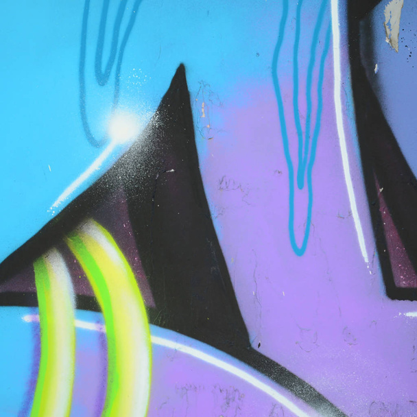 Fragment von Graffiti-Zeichnungen. die alte Wand mit Farbflecken im Stil der Street-Art-Kultur dekoriert. farbige Hintergrundtextur in kalten Tönen. - Foto, Bild