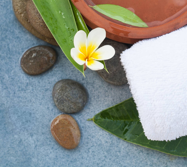 Spa flower and stones for healhty relax massage treatment on blue table background. - 写真・画像