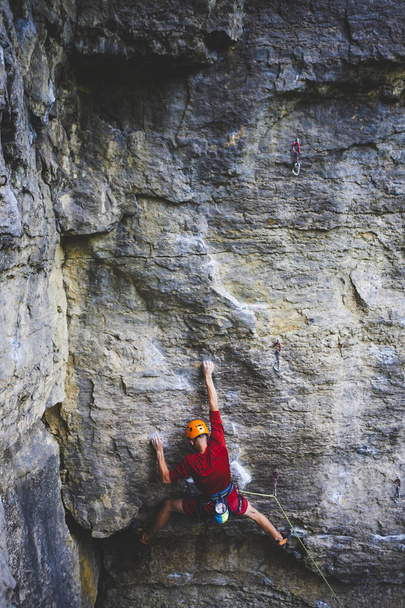 ヘルメットの男が岩に登る。自然の中でクライミング。屋外でフィットネス。積極的なライフスタイル。極端なスポーツだ。アスリートは自然救済の訓練を受ける。絵のような場所での訓練。トルコでの登山. - 写真・画像