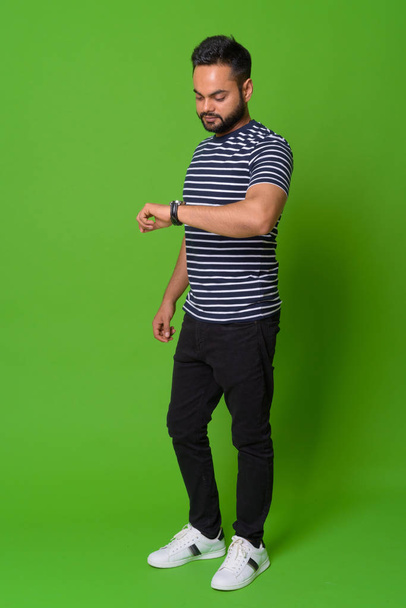Genç Hintli yeşil bir arka plana dayanır sakallı - Fotoğraf, Görsel