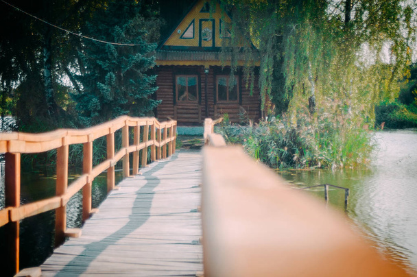 деревянный мост к одинокому охотничьему дому на острове
 - Фото, изображение
